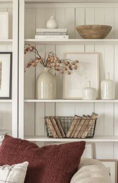 a living room filled with lots of furniture and bookshelves covered in white bookcases