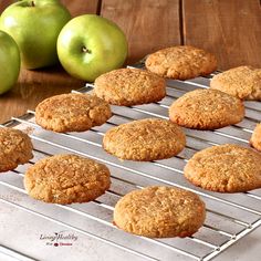 cookies cooling on a rack with apples in the backgroung, and two green apples next to it