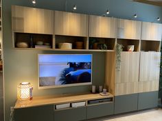 a flat screen tv sitting on top of a wooden entertainment center in a living room