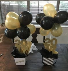 some black and gold balloons are on a table