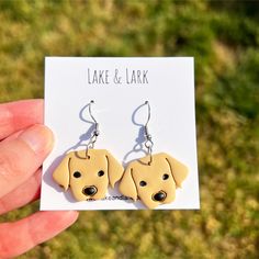 a pair of earrings with a yellow dog on it