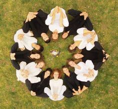 a group of people standing in the middle of a circle on top of green grass