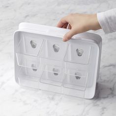 a person is holding an ice box with six compartments