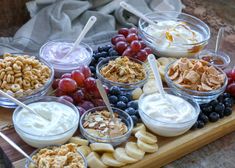 an assortment of fruit and yogurt on a wooden platter