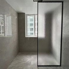 an empty room with a glass door and window in the corner on the right side