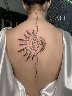 a woman's back with a sun tattoo on it