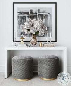 two stools with flowers and candles on them in front of a white console table