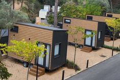 several tiny houses are lined up in the sand