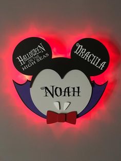 a lighted mickey mouse head with the name noah on it's face and red bow tie