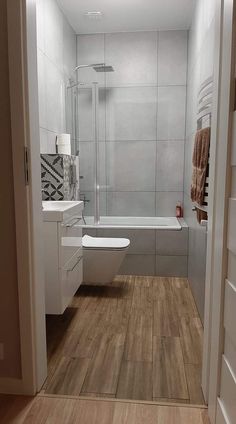 a bathroom with wood flooring and white walls