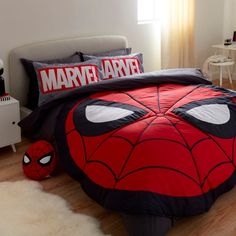 a bed with a spiderman comforter and pillows