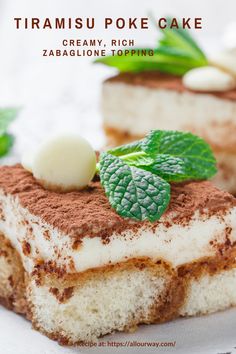 there is a piece of cake with cream and green leaves on the top, sitting on a white plate