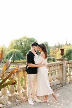 a man and woman standing next to each other on a bridge