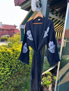 "Beautiful handmade hamsa hand black kimono robe, designed with cotton fabric, it flows as you move for a comfortable wear. Beach cover up, a kimono with hamsa hand designs. This is a lovely, good-quality kimono, with traditional breathable kimono sleeves.        A belt that ties around the waist. Great to wear around the house, on beaches, or to dress up with some jeans & a T-shirt, covering up on the beach with a swimsuit.         We love kimonos as they are so versatile. They also make really special & unique birthday, valentines Day, Christmas gifts, and Mother's Day gifts. The perfect combination of comfort and style, this kimono is a great addition to your new season wardrobe.    Cotton Fabric and Handmade      Length from shoulder: 115 CM Width: 130 CM Kimono Size: One/Standard size Traditional One Size Kimono For Summer, Traditional Long Sleeve Kimono For Beach, Bohemian Cotton Open Front Kimono, Black Cotton Kaftan For Vacation, Black Cotton Kimono For Summer, Hippie Style Cotton Long Sleeve Kimono, Traditional Open Front Kimono For Festivals, Hippie Style Long Sleeve Cotton Kimono, Bohemian Cotton Robe For Festivals