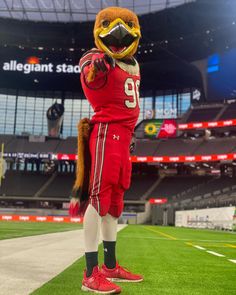 a football player in a red uniform standing on the sidelines at an empty stadium