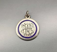 a silver and blue pendant with the letter b on it