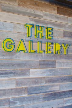 the sign on the side of a building that says the gallery is painted yellow and green