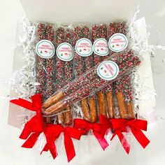 a box filled with assorted candy canes and candies next to red bows