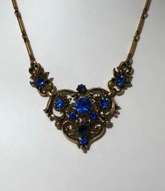 Signed Coro Vintage Antique Necklace SIGNED CORO Blue Rhinestone With Jewelers Brass Gold Tone Chain Jewelry app 16 inch Vintage Antique Necklace SIGNED CORO with Gold Tone Heart and Blue Rhinestones set through out has period 1940's scroll work and is in great condition. Spring Ring clasp. No missing rhinestones, great sparkle and shiny gold tone Jewelers Bronze Base Metal Over all is in excellent condition Shipped first class free 2-5 days Czech Glass Jewelry, Silver Casting, Coro Jewelry, Scroll Work, Medieval Jewelry, Crystal Necklaces, Antique Necklace, Brass Gold, Chain Jewelry