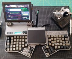 an old computer keyboard sitting on top of a table next to other electronic devices and tools