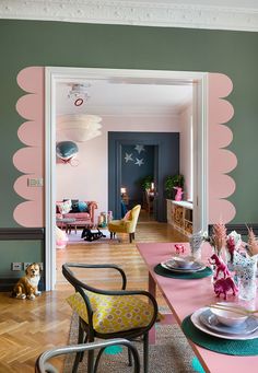 the dining room is decorated in pink and green