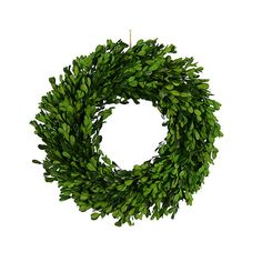 a green wreath is hanging on a white wall and it's ready to be hung