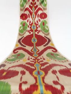 an ornately designed vase is shown against a white background with green, red and yellow accents