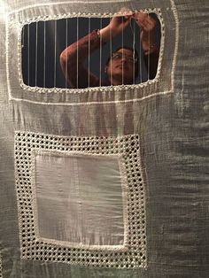 a man is seen through the window of a piece of cloth that has been woven into it