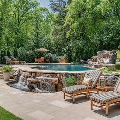 a backyard with a pool, waterfall and lounge chairs in the foreground is an outdoor dining area