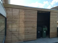 a wooden building with a trash can in it