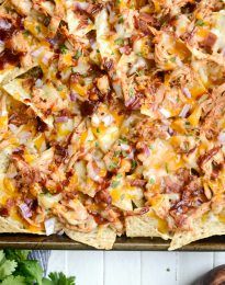 an overhead view of nachos on a baking sheet with tortilla chips