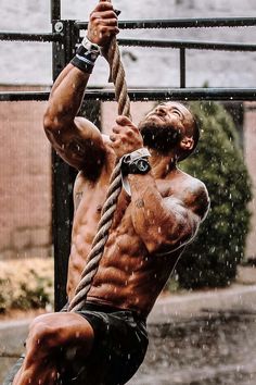 a man hanging from a rope in the rain