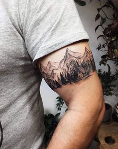 a man with a mountain tattoo on his arm