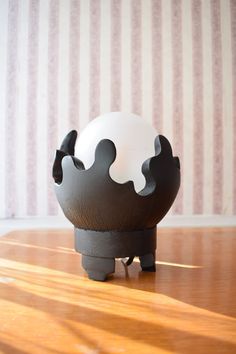 a black and white vase sitting on top of a wooden table