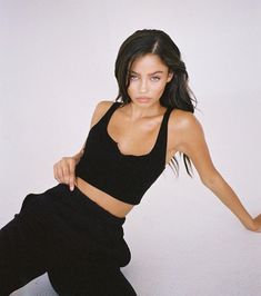 a woman in black top and pants posing for the camera