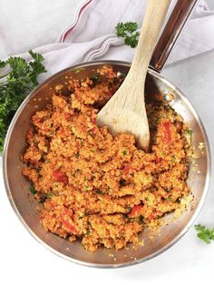 a pan filled with food and a wooden spoon