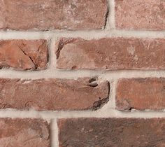 a brick wall that is made out of red bricks and has no mortar on it