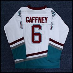 a hockey jersey with the number 6 on it, sitting on top of a blue carpet