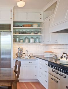 a kitchen with white cabinets and wooden floors