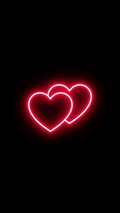 two heart shaped neon signs on a black background in the shape of a pair of hearts