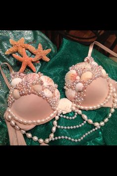 two pink bras with pearls and seashells on them