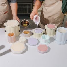 a person pouring batter into a bowl on top of a table