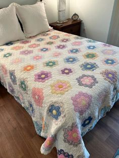 a bed with a floral quilt on it