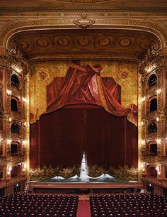 an empty theater with red curtains and seats