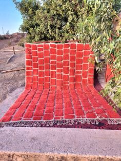 a red blanket sitting on top of a cement slab