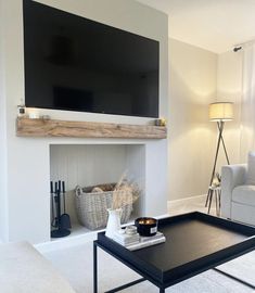 a living room filled with furniture and a flat screen tv mounted on the wall above a fireplace