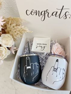 two coffee mugs in a box with congratulations written on them