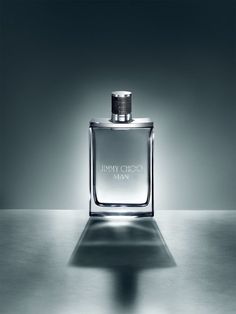 a bottle of jimmy choo man perfume on a table with the light shining through it