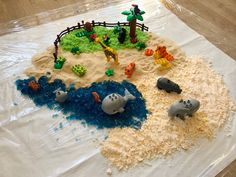 a plastic bag filled with sand and toys on top of a wooden floor covered in plastic