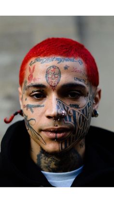 a man with tattoos and piercings on his face